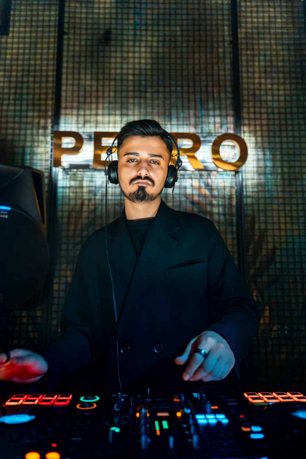 Petro Cocktail Bar — Samet Karabina in headphones at the decks under the PETRO sign