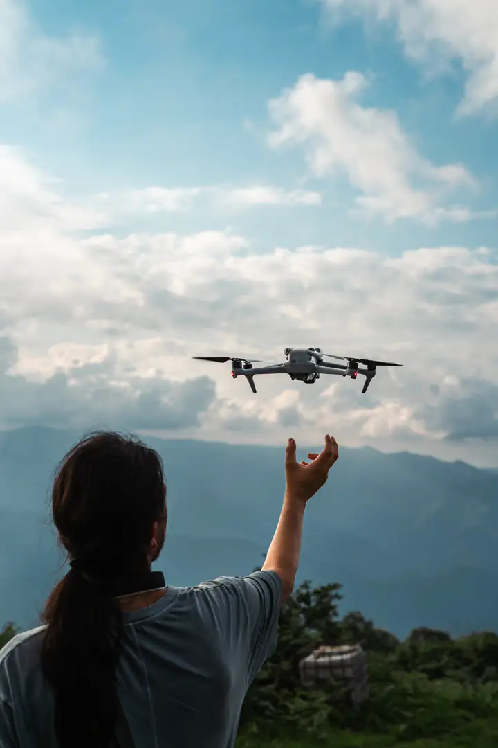 Dağ manzarasında elinden dron kaldıran ekip üyesi
